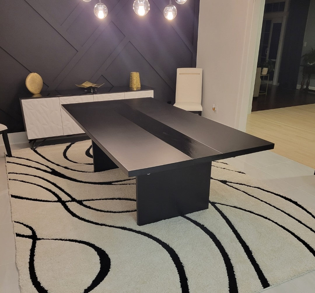 Detail shot of the high-gloss center stripe on a custom black plinth-base table