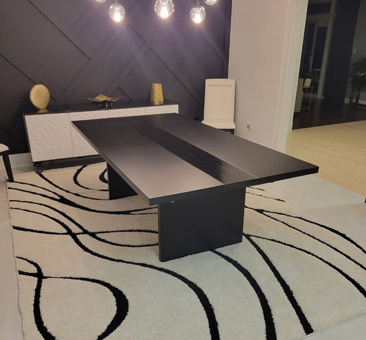 Detail shot of the high-gloss center stripe on a custom black plinth-base table