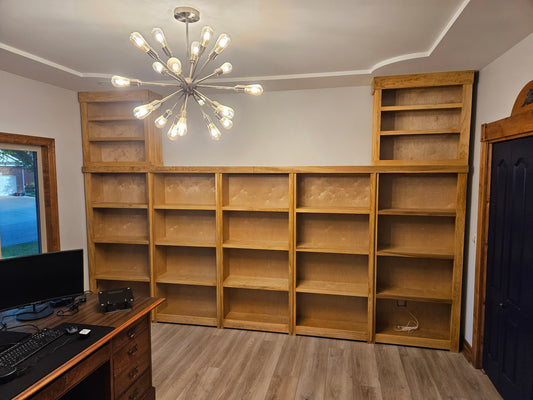 164-inch wide custom Stockton Mill architectural library installation in Wichita featuring seventeen storage bays and a premium alder-toned finish on poplar wood.